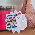 Sticker with text on a surface with a pink candle and vase in the background
