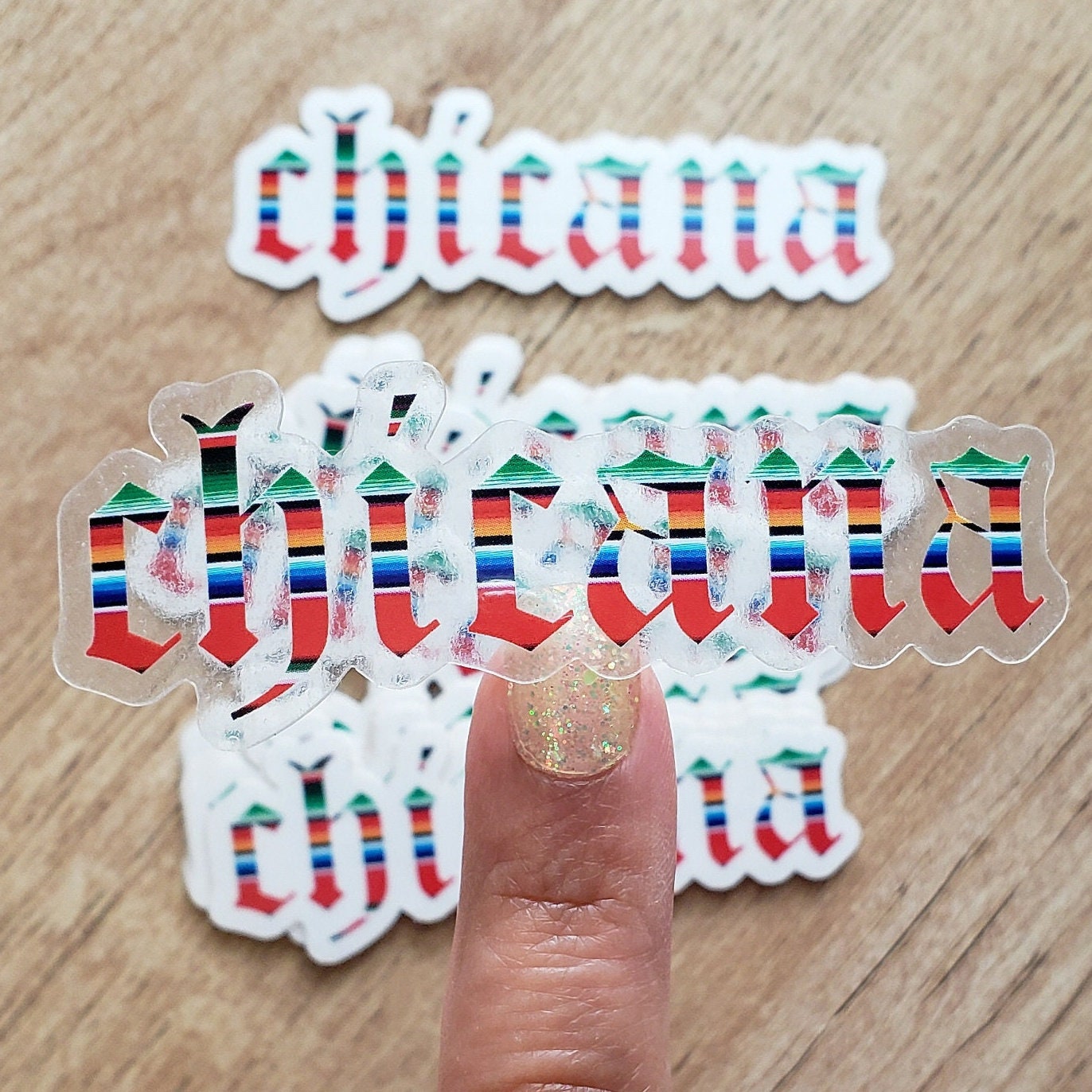 Clear 'Chicana' sticker in front of a wooden surface