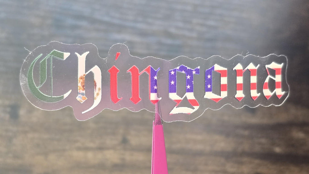Sticker with 'Chingona' text in a colorful design on a reflective surface