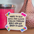 Note to self sticker on a surface with a pink candle and vase in the background