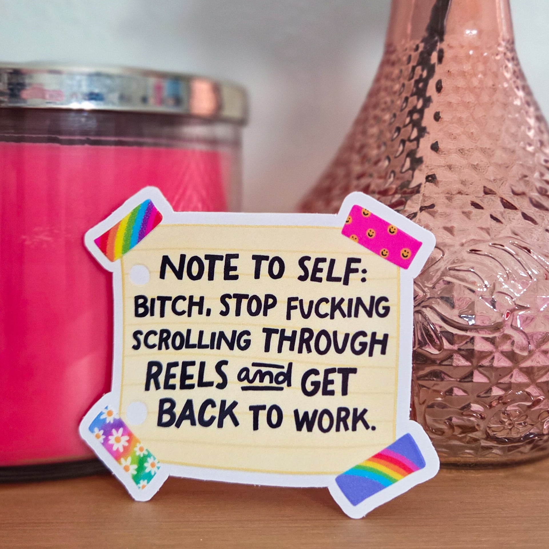 Note to self sticker on a surface with a pink candle and vase in the background